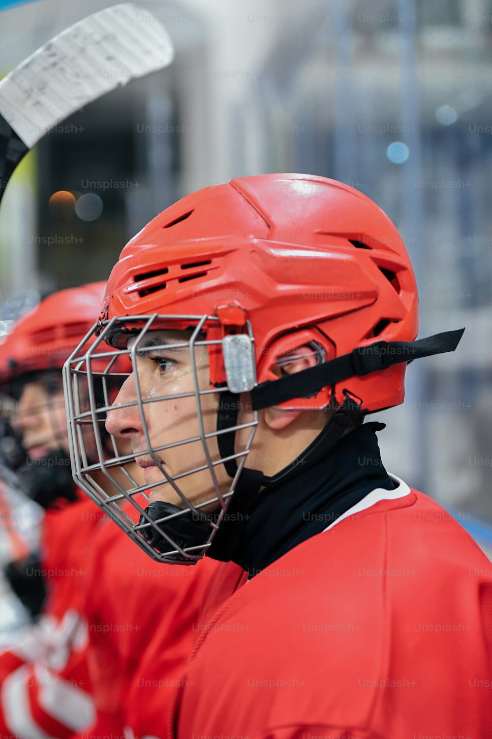 Un jugador de hockey con un casco rojo y sosteniendo un palo de hockey