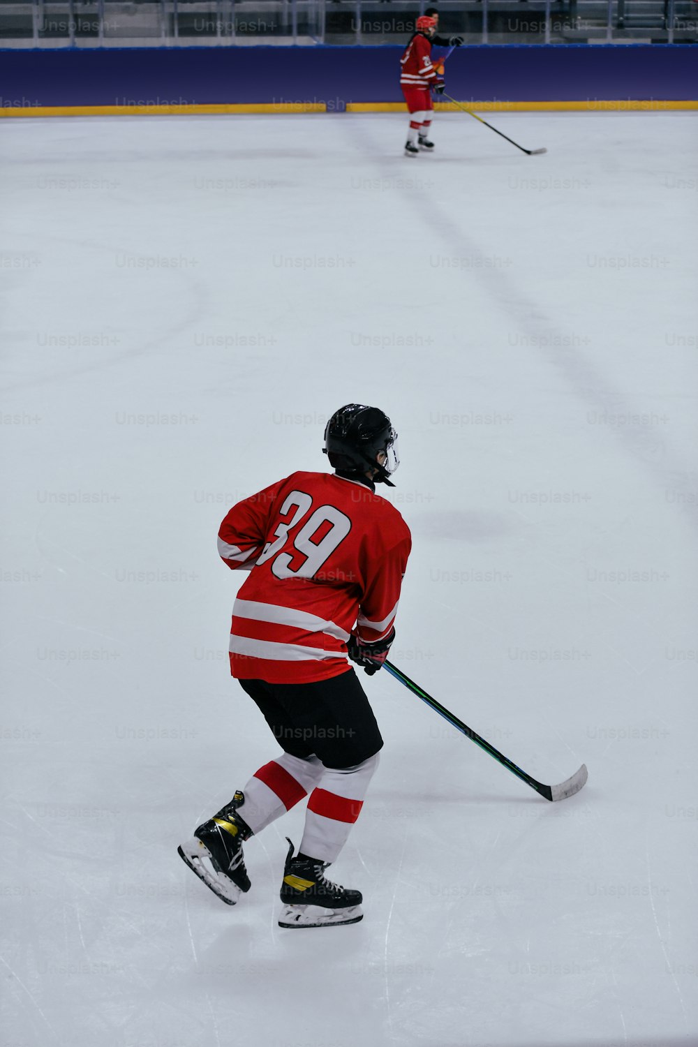 a hockey player in a red jersey skating on the ice