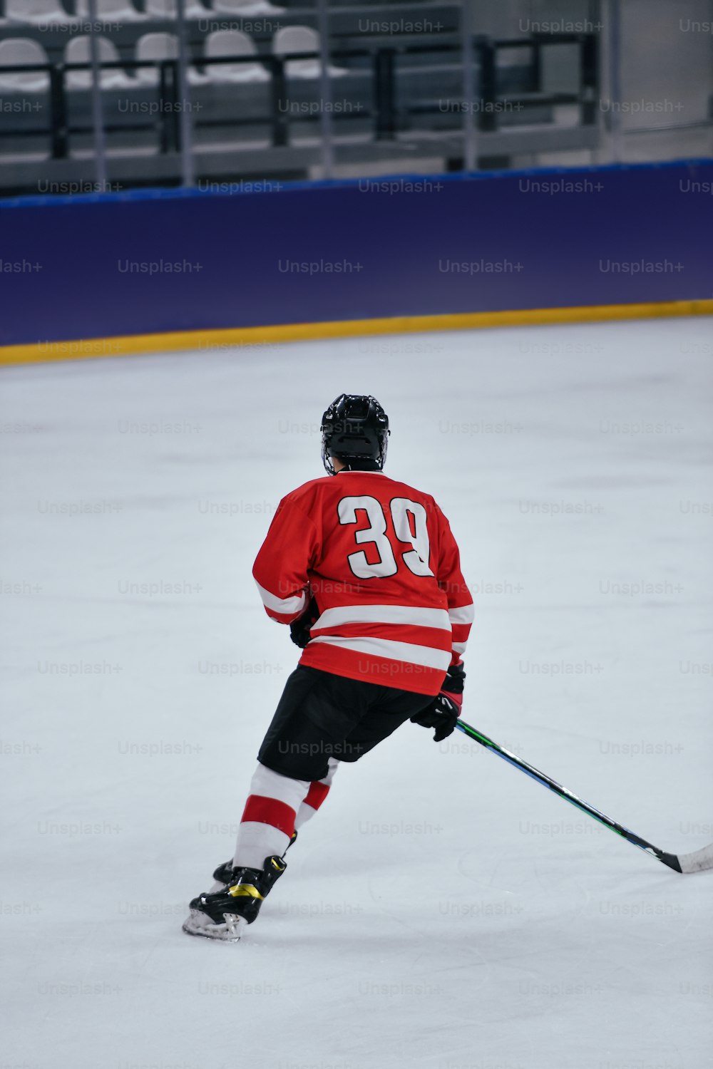 um jogador de hóquei em uma camisa vermelha patinando em uma pista de gelo