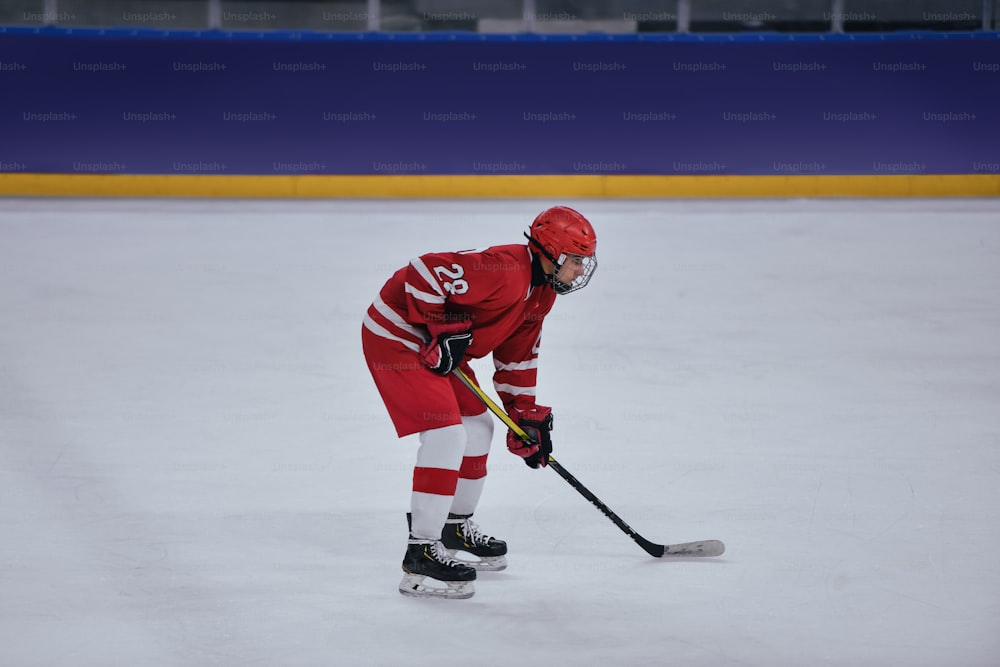 uma pessoa em um uniforme vermelho jogando hóquei no gelo