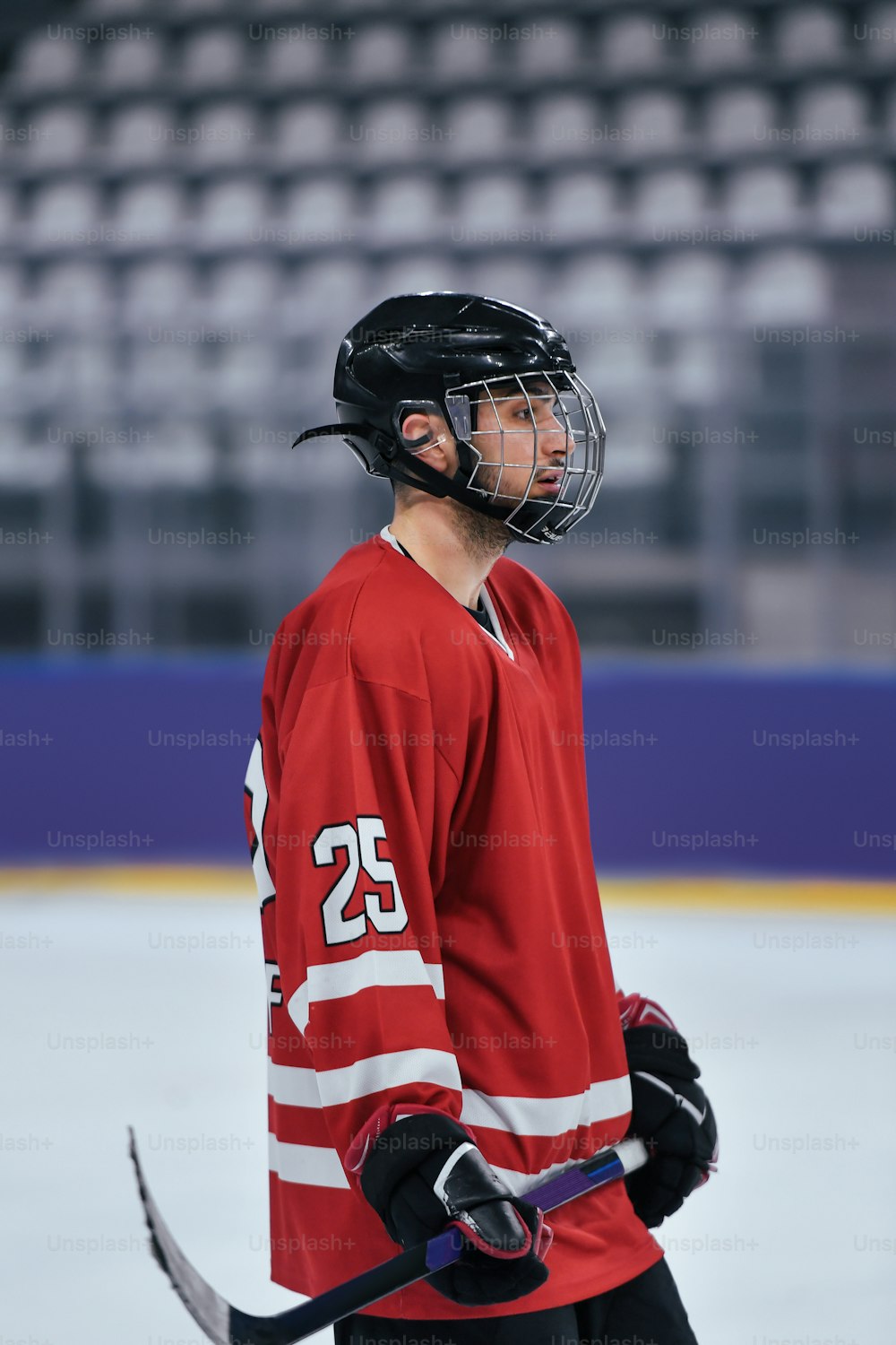 Un homme portant un chandail rouge tenant un bâton de hockey