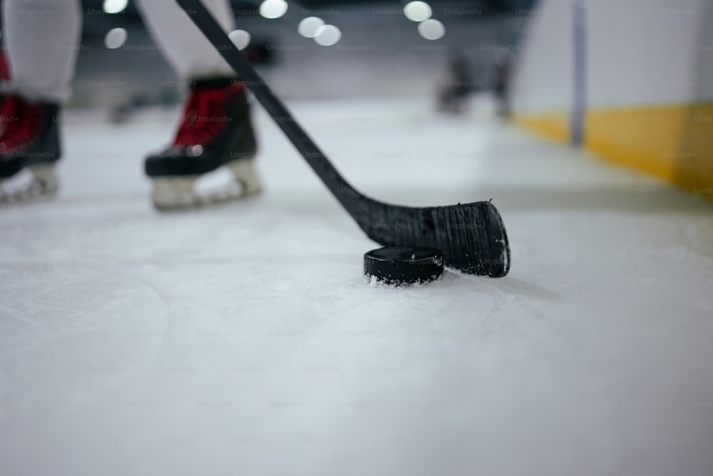 Un primer plano de un palo de hockey y un disco de hockey