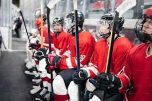 a group of hockey players sitting next to each other