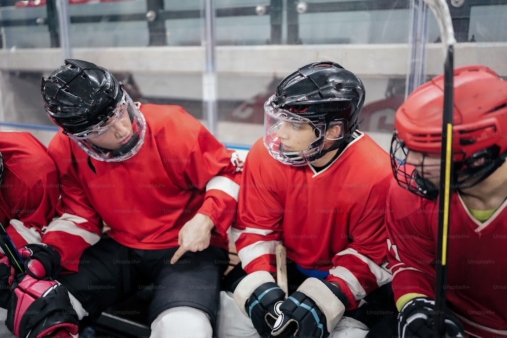 Un gruppo di giocatori di hockey seduti uno accanto all'altro