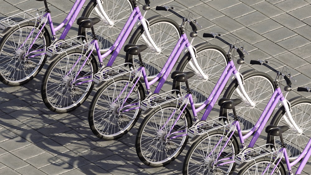 Una fila de bicicletas moradas estacionadas una al lado de la otra