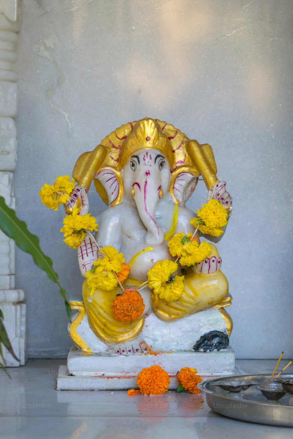 a statue of an elephant with flowers around it