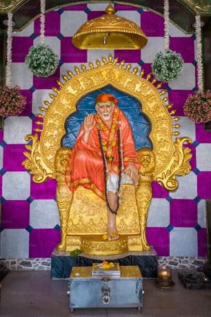 a statue of a man sitting on a golden throne