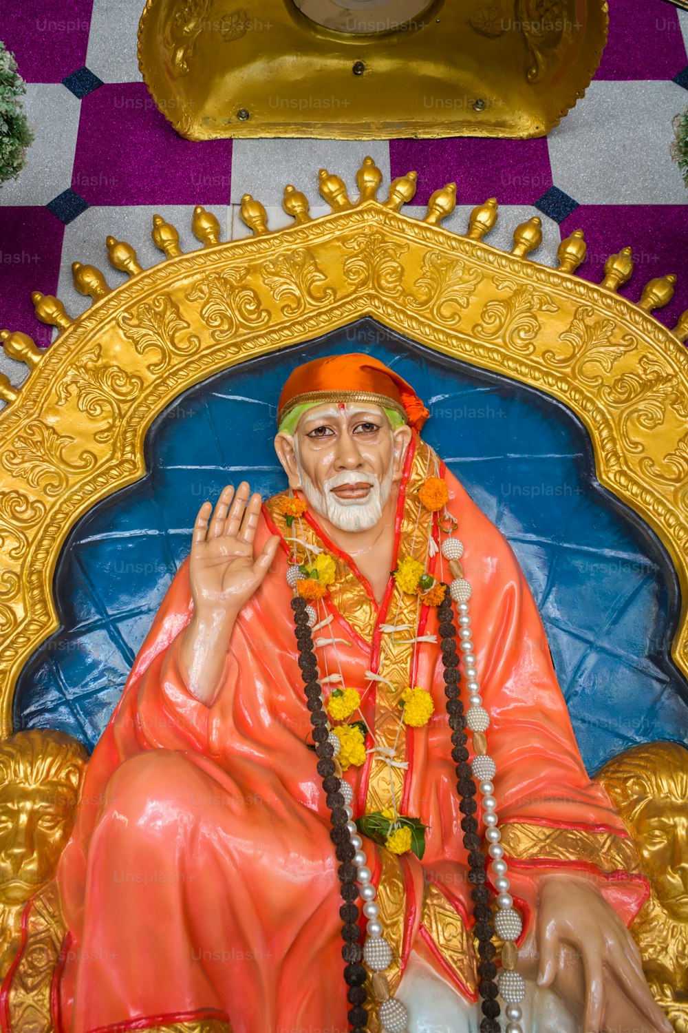 a statue of a man sitting on top of a blue chair