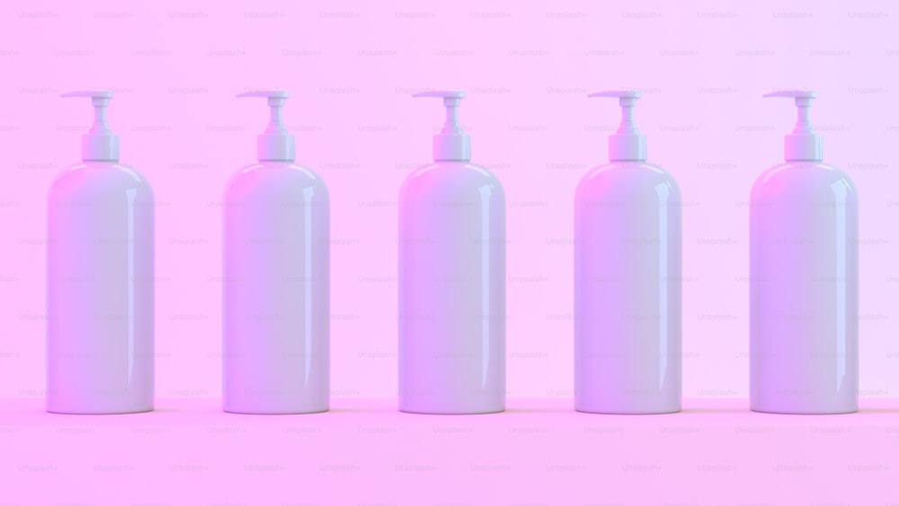 a row of white bottles with soap dispensers on a pink background