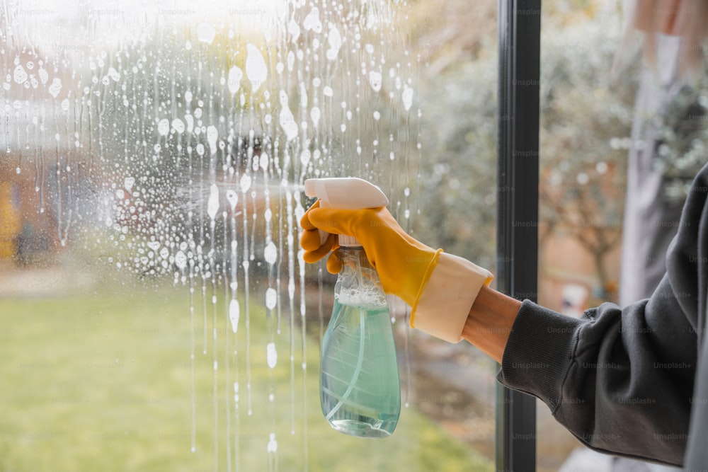 a person in yellow gloves is holding a bottle of water