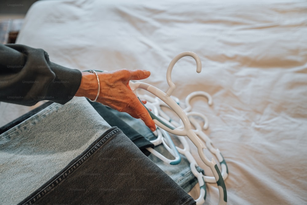 a person sitting on a bed holding an object in their hand