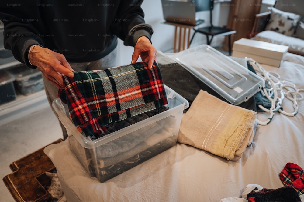 a person holding a plaid cloth in a plastic container