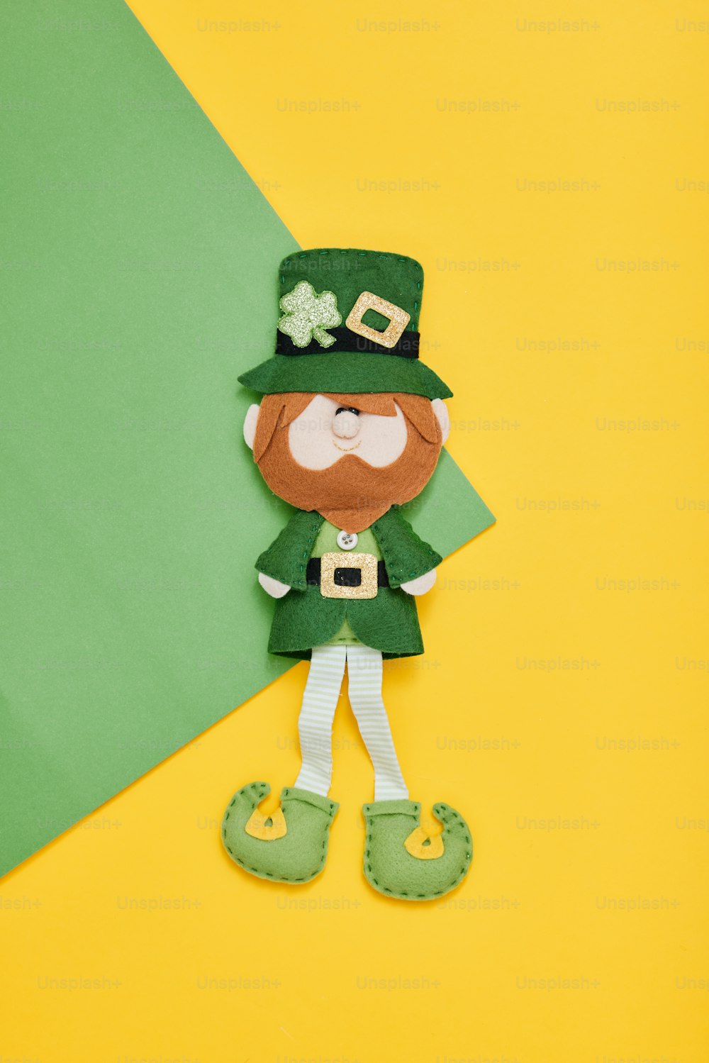 Una muñeca de papel del Día de San Patricio sobre un fondo amarillo y verde