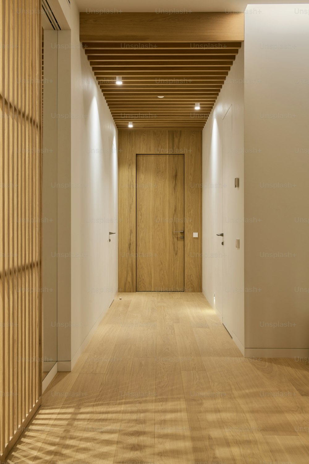 a long hallway with a wooden ceiling and white walls