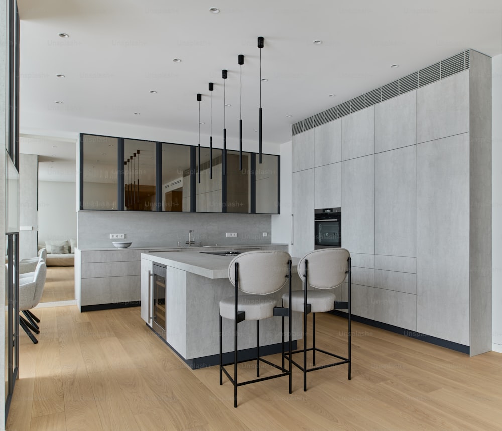 a modern kitchen with a bar and stools