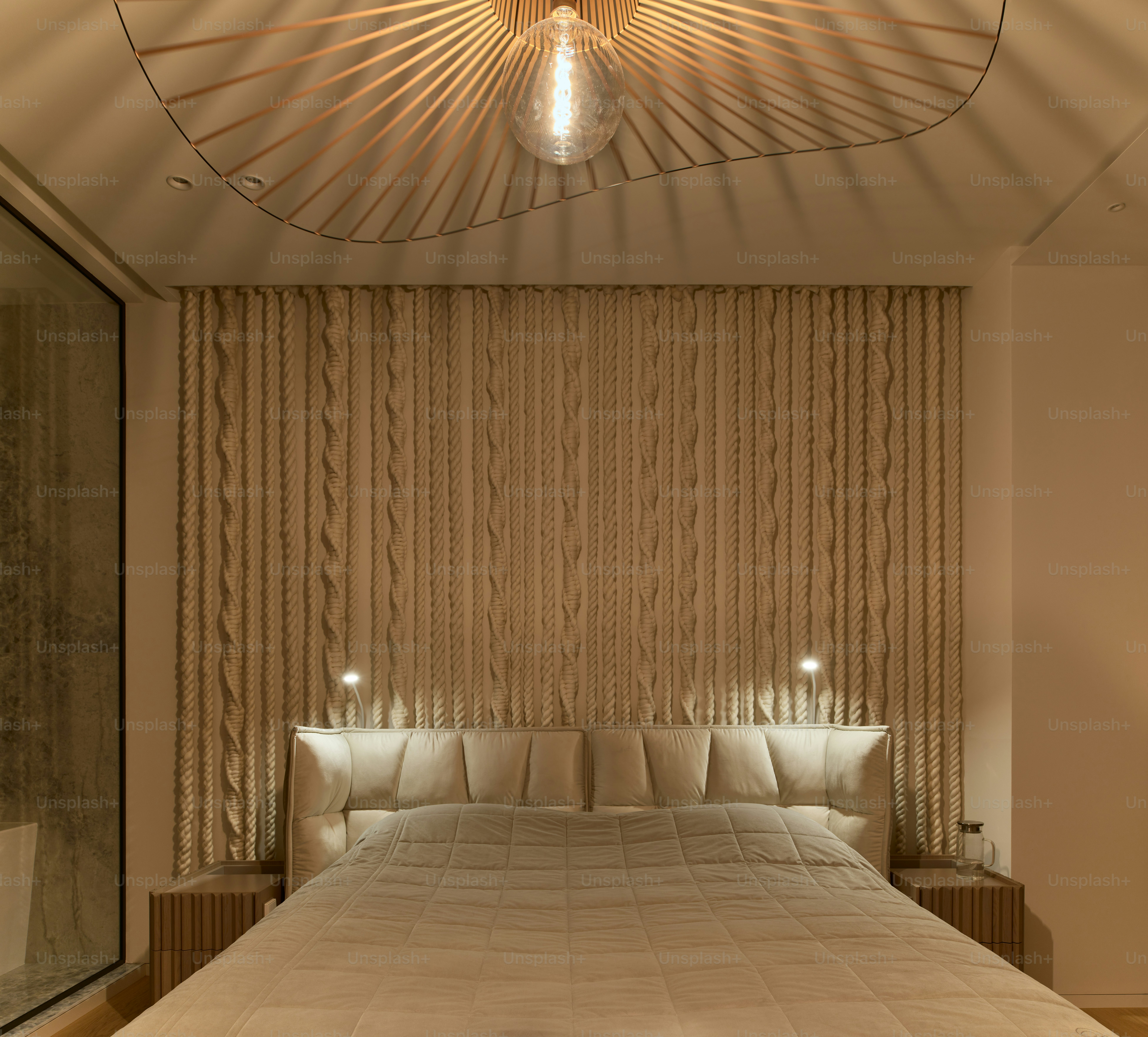 a bedroom with a large bed and a chandelier