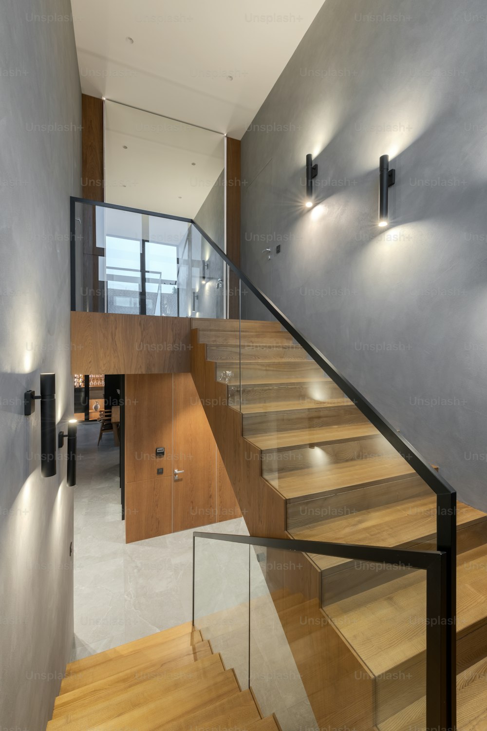 a staircase with a glass railing and wooden steps