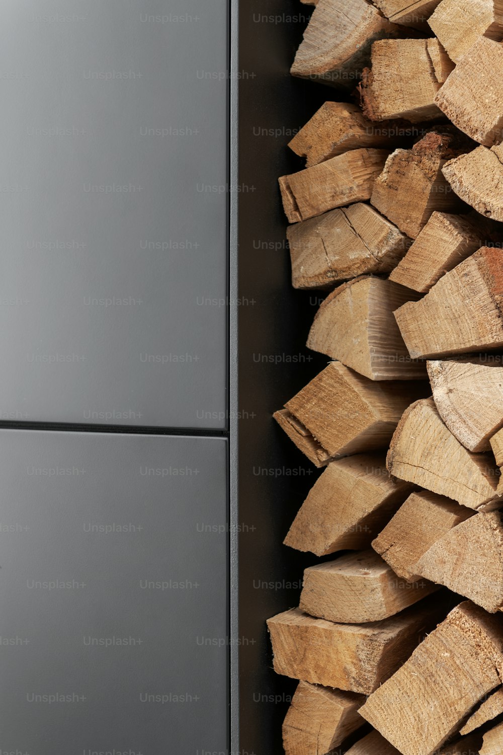 Una pila de madera sentada junto a un refrigerador