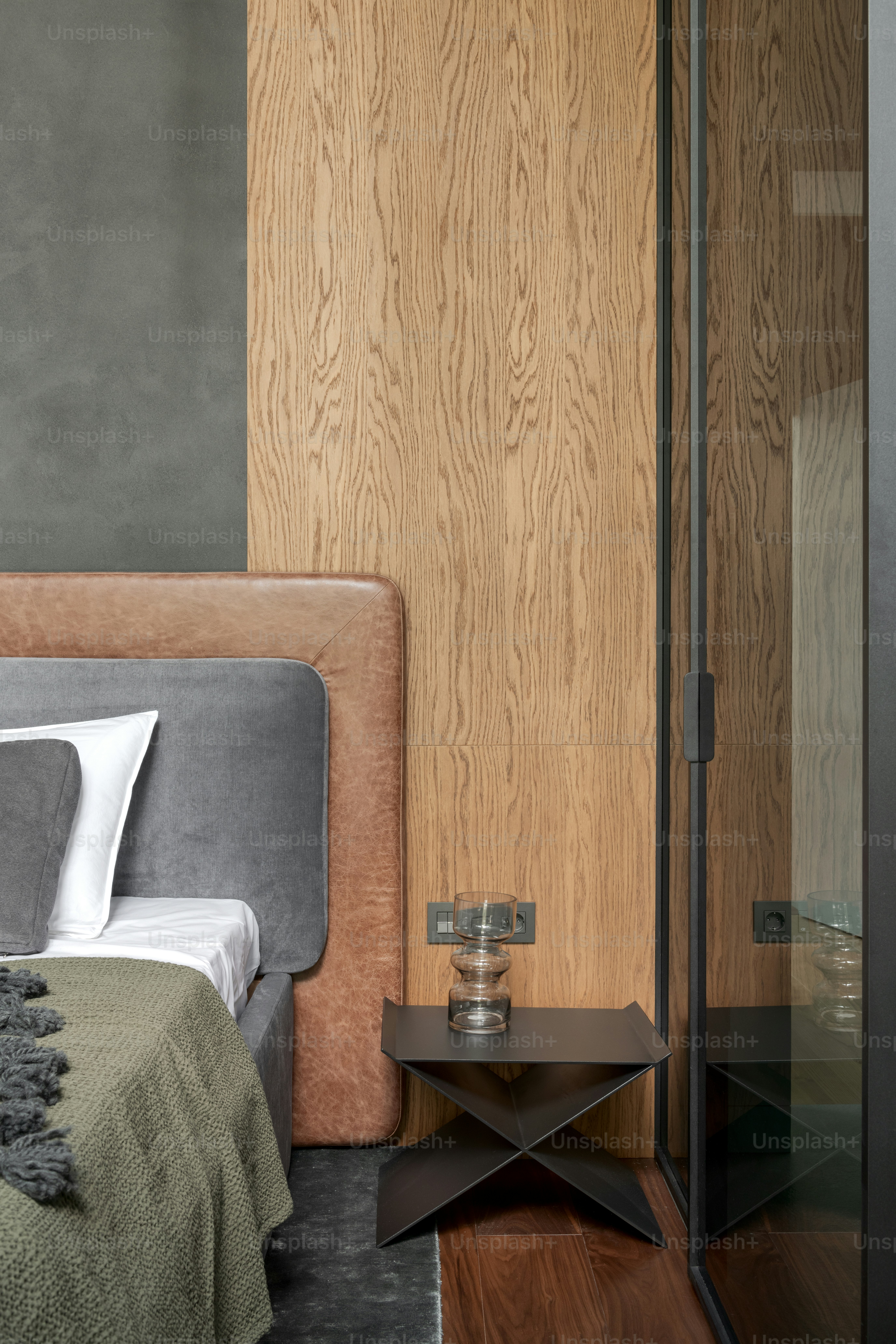 ein Bett neben einer Holzwand