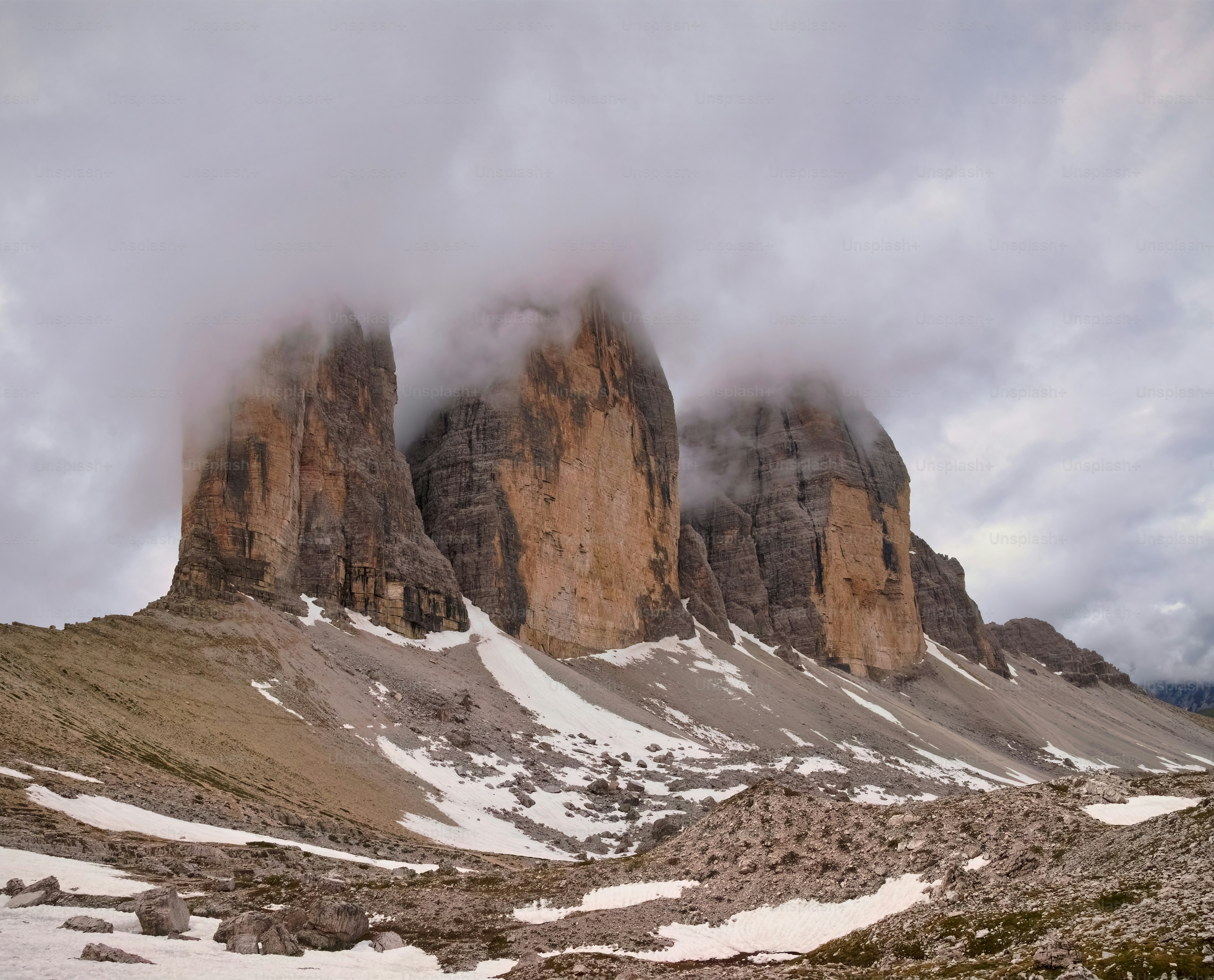 Un gruppo di montagne coperte di neve sotto un cielo nuvoloso