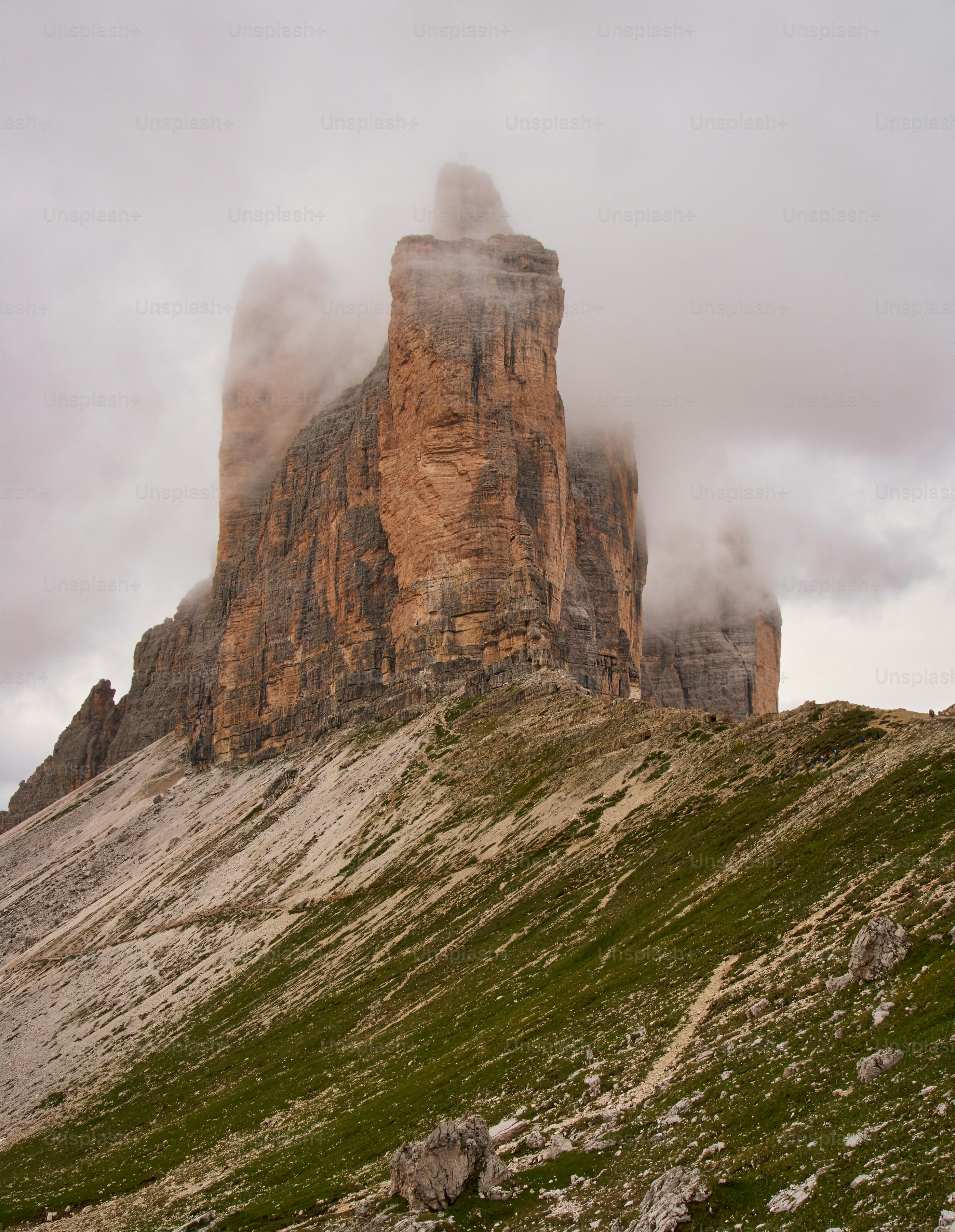 una grande formazione rocciosa su una collina erbosa