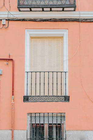 a pink building with a white door and window