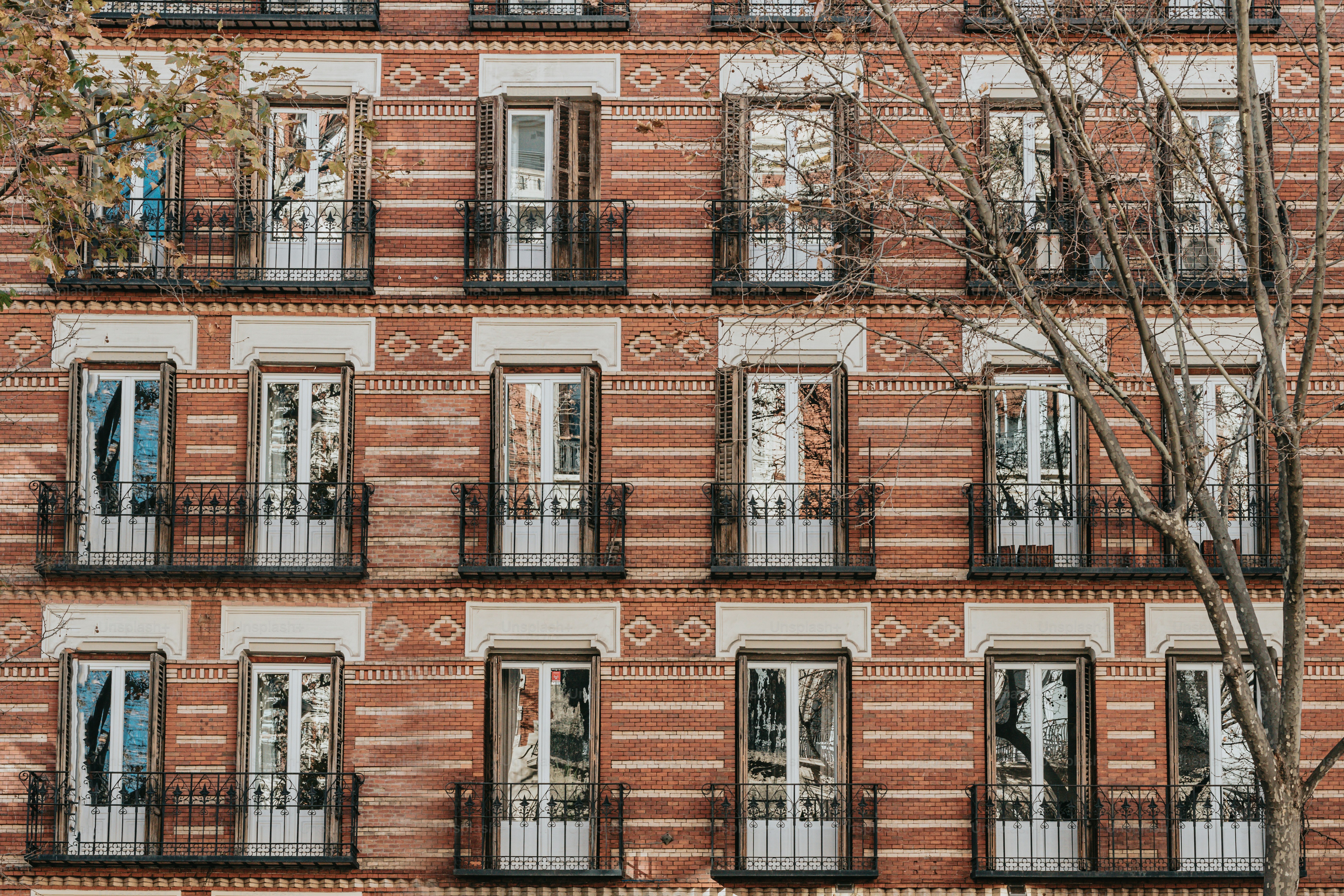 a tall brick building with many windows and balconies