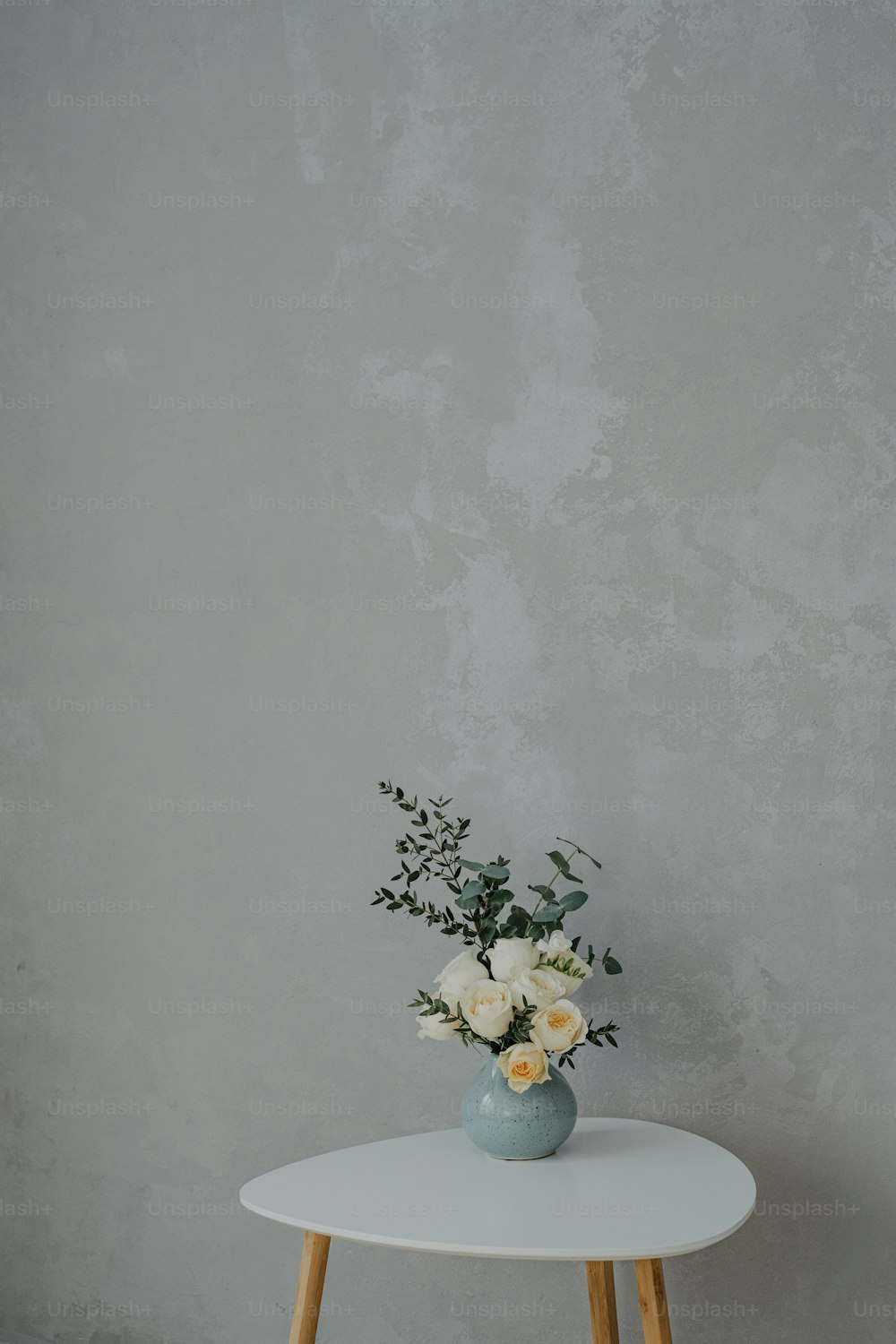 a white table with a vase of flowers on it