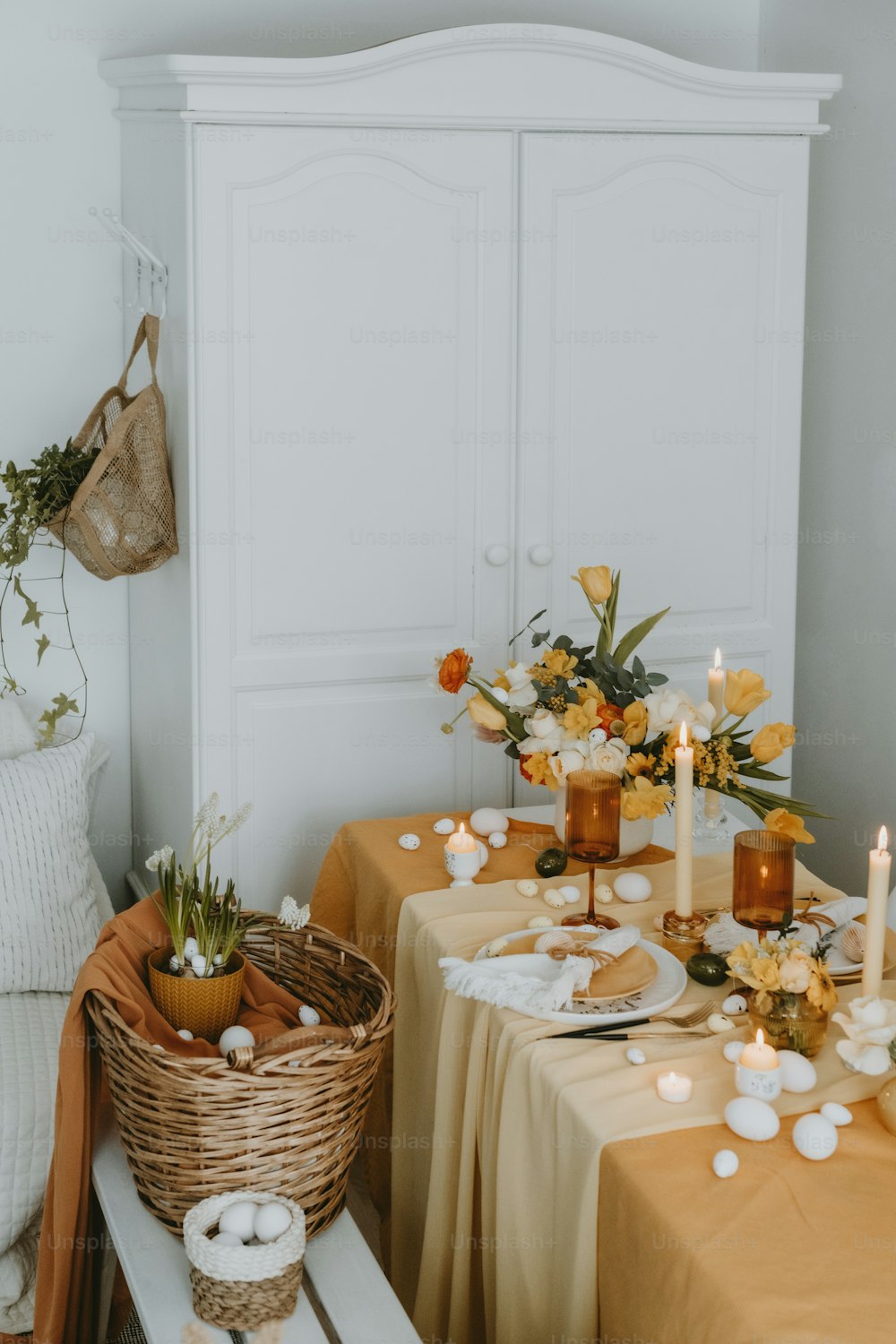 a table with a basket of flowers and candles