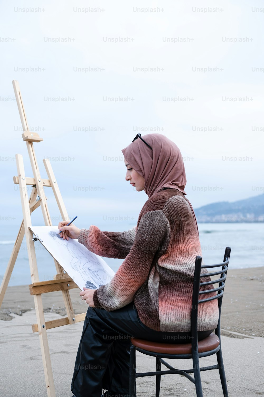 a woman sitting on a chair writing on a piece of paper
