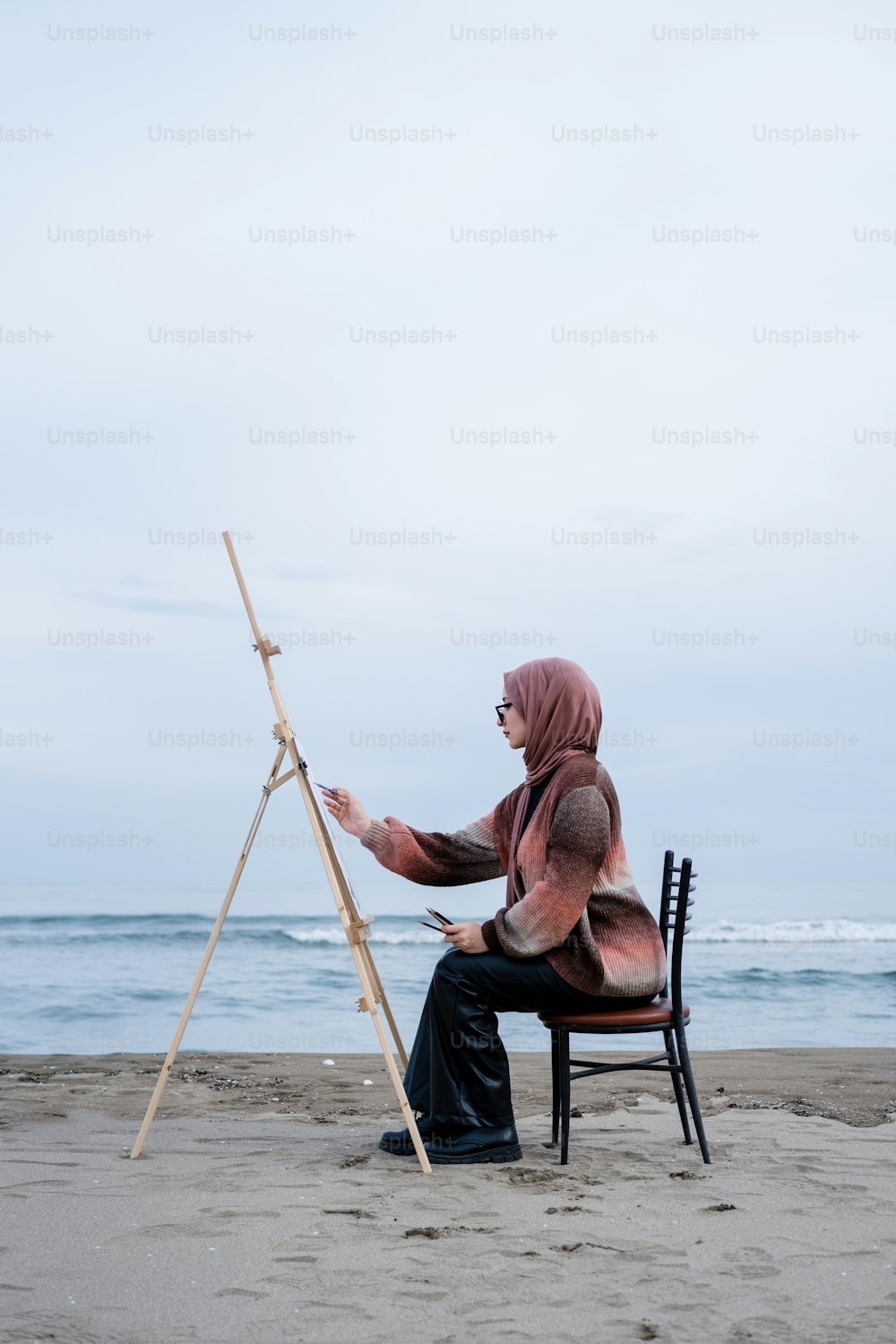 una persona seduta su una sedia su una spiaggia