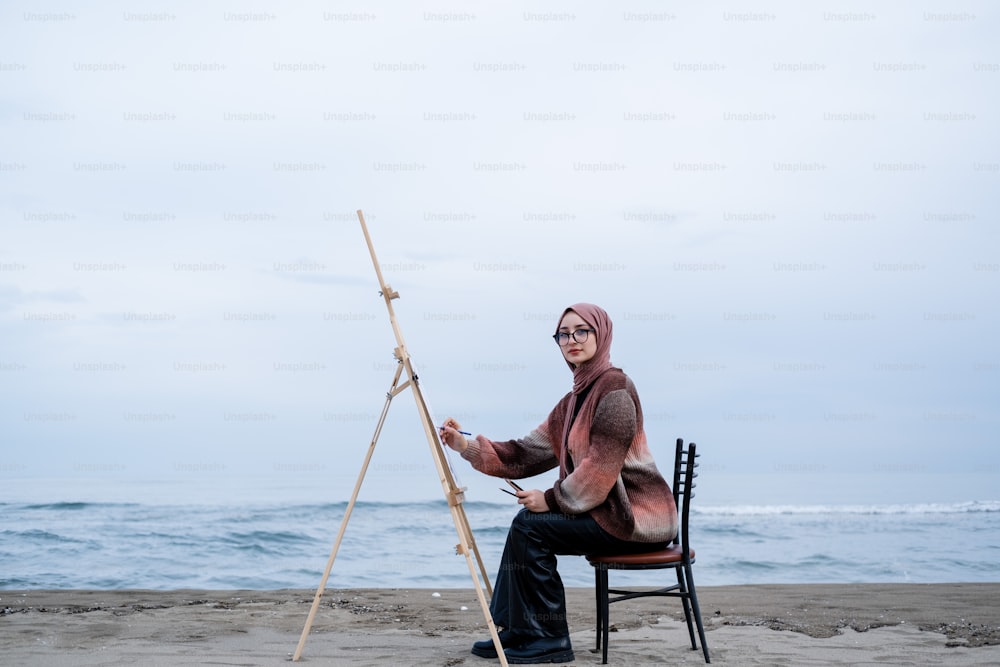 una persona seduta su una sedia su una spiaggia