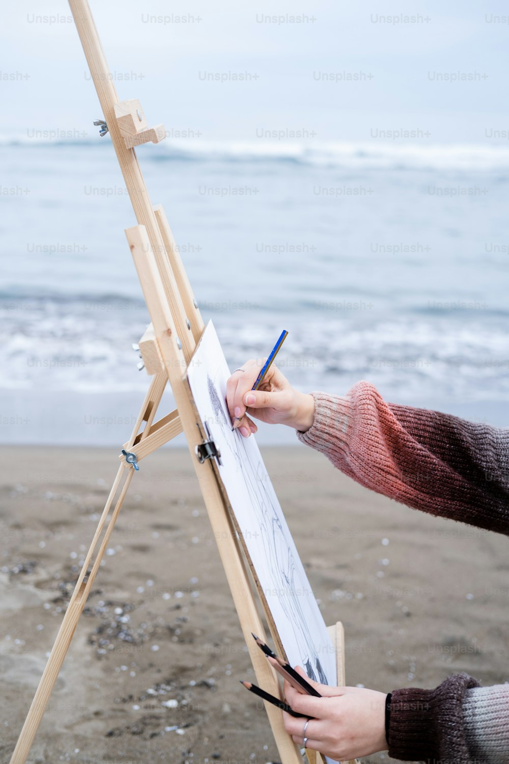 a person writing on a piece of paper next to an easel