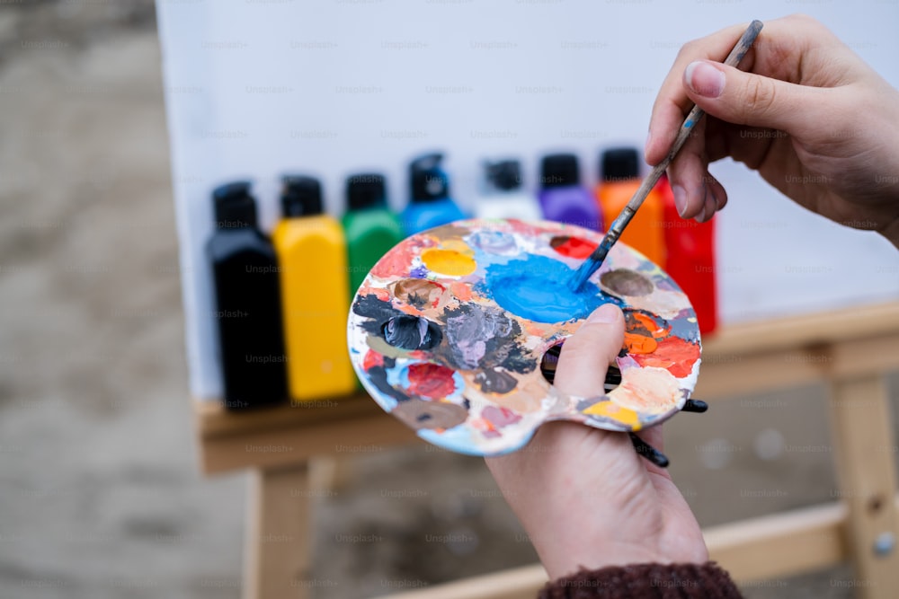a person holding a paintbrush and a paint palette