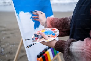 a person holding a paintbrush and a palette