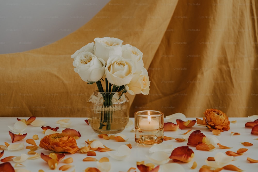 a vase of flowers on a table with a candle