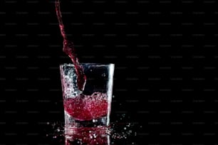 un bicchiere pieno di liquido rosso sopra un tavolo