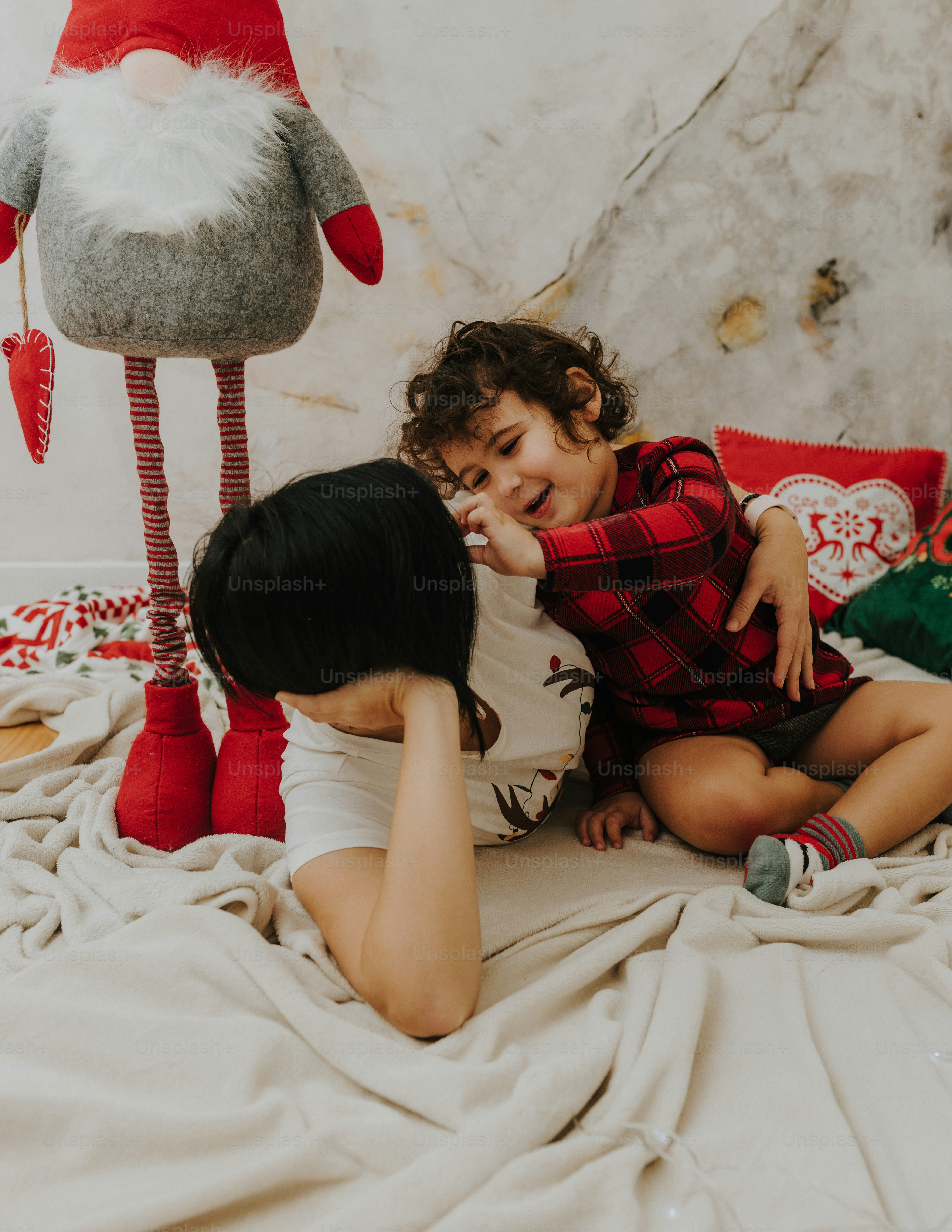Foto Un par de niños acostados encima de una cama – Maternidad Imagen ...