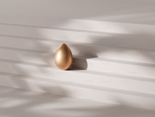 a golden egg on a white wall