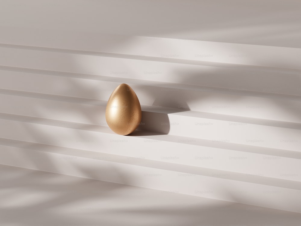 a golden egg on a white wall