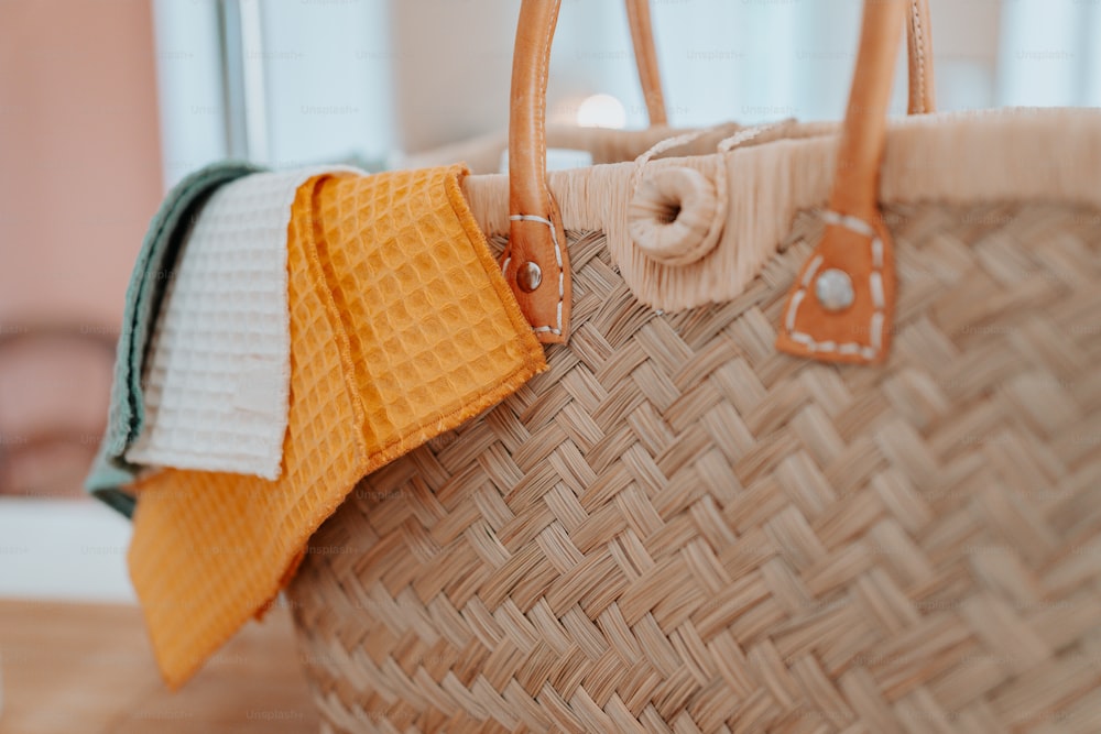 a wicker basket with three towels hanging from it