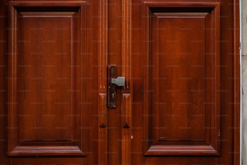 a close up of a wooden door with a metal handle