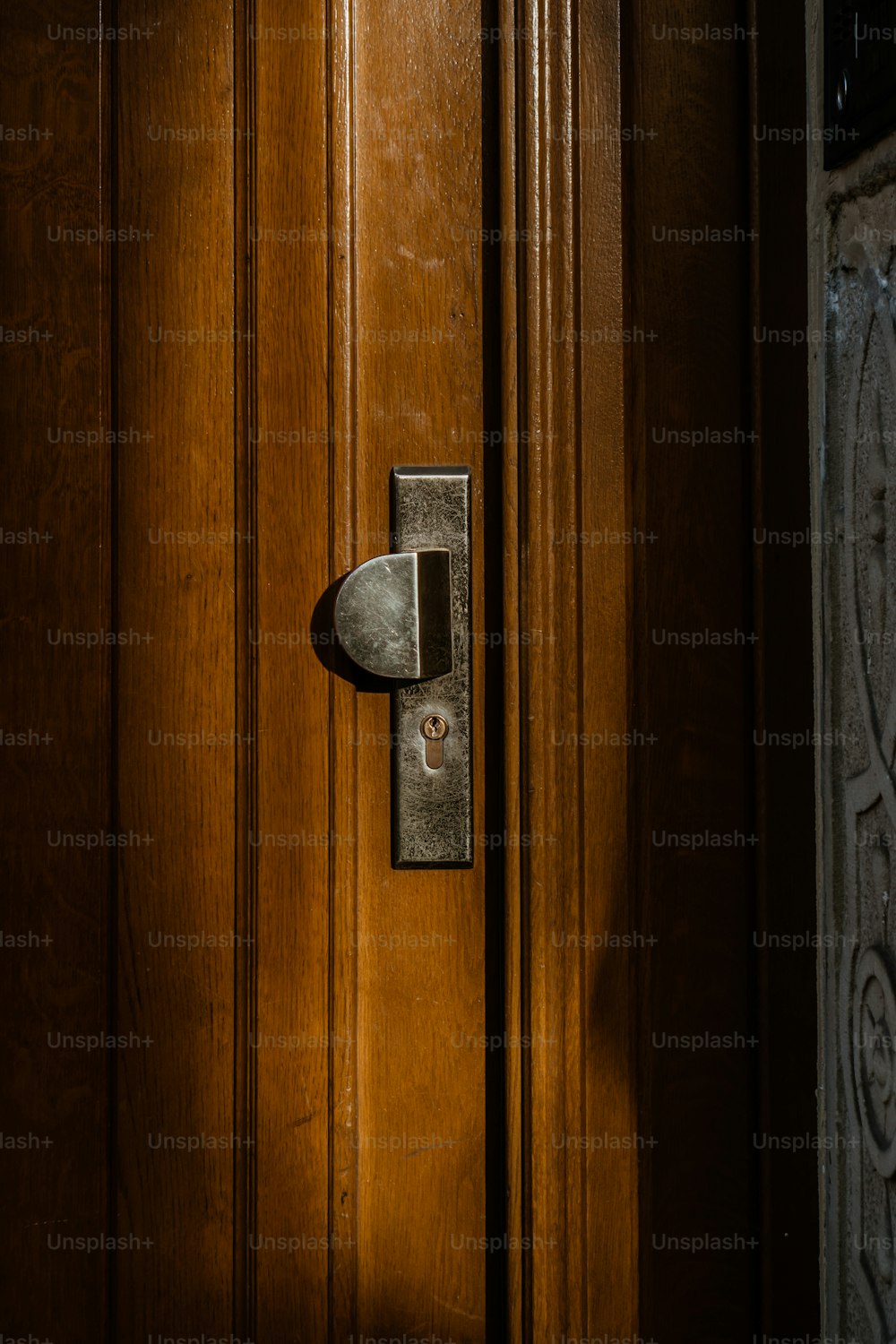 a close up of a door handle on a wooden door