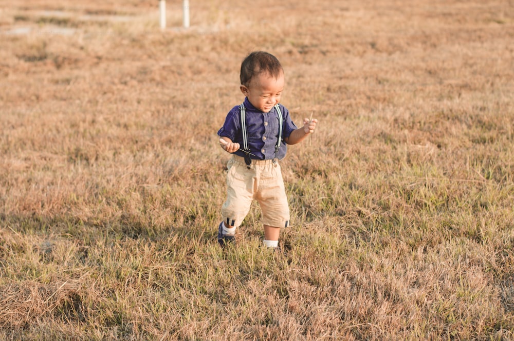 a little boy that is standing in the grass