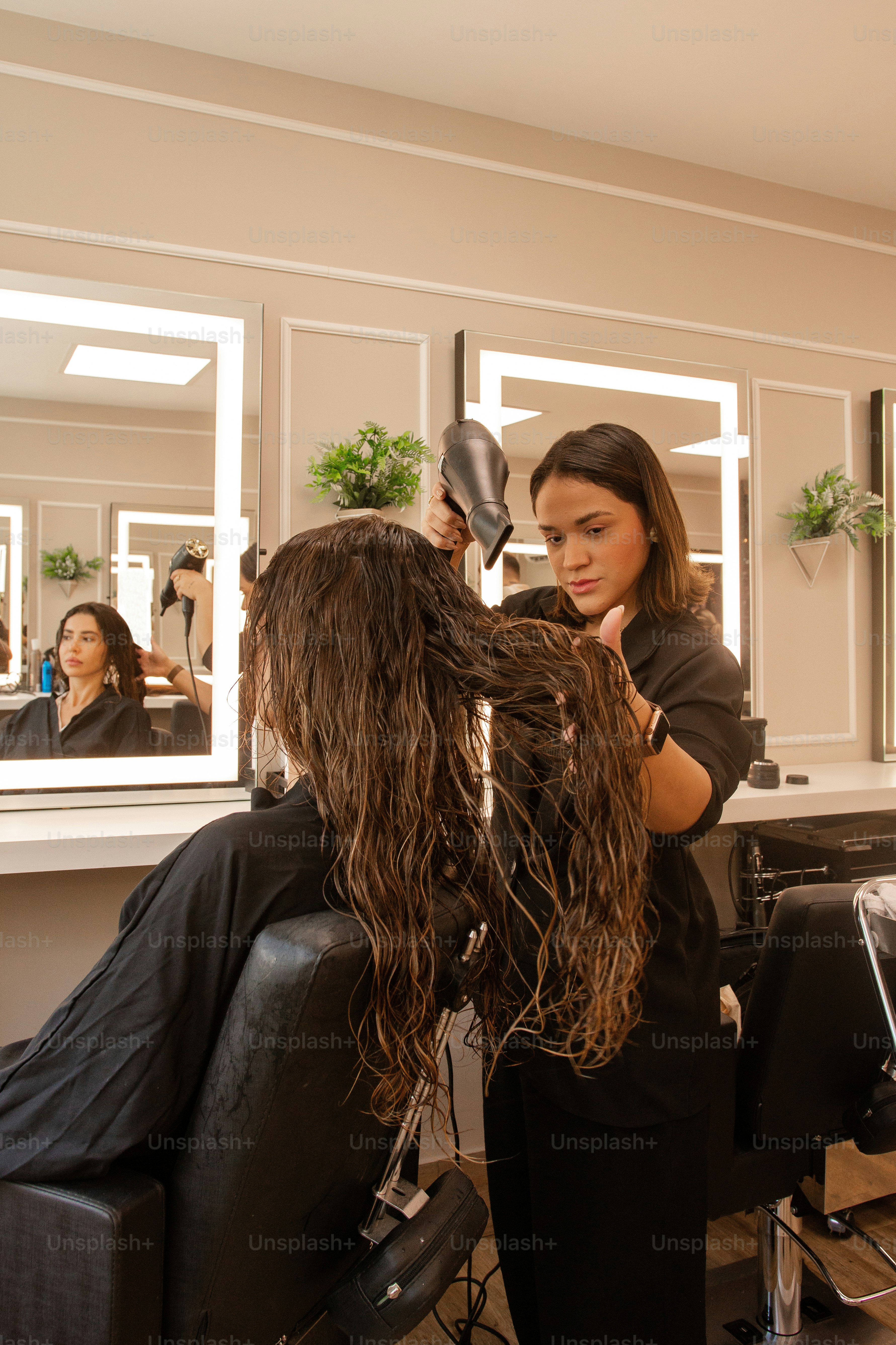 Una mujer sentada en una silla con secador de pelo