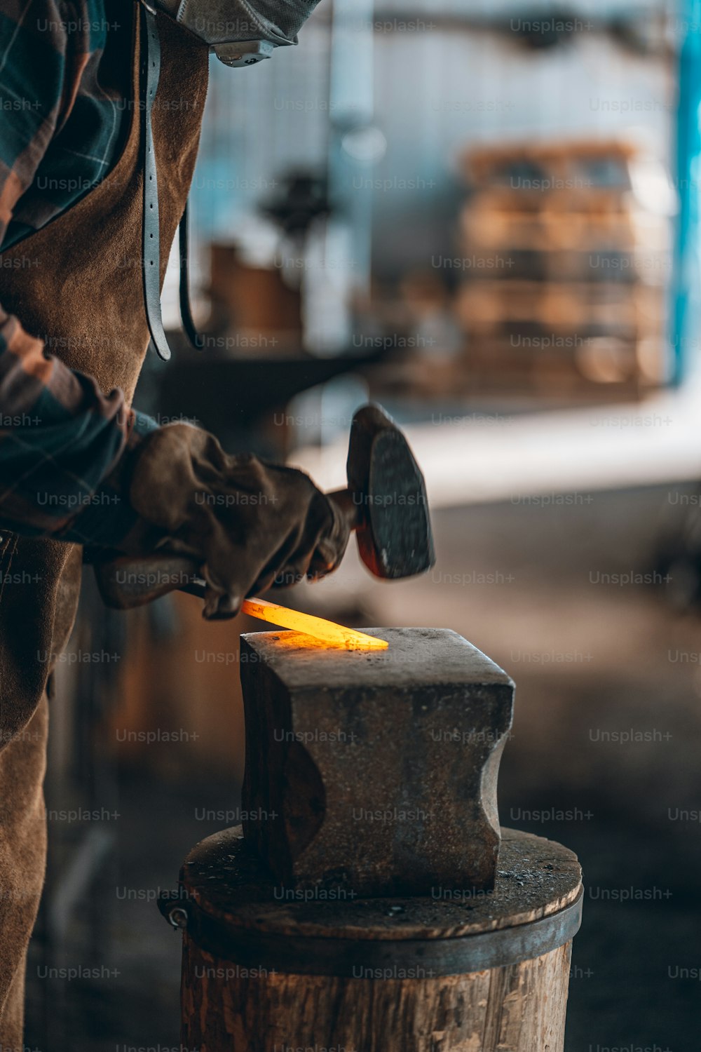 Un hombre trabajando con un martillo en un pedazo de metal