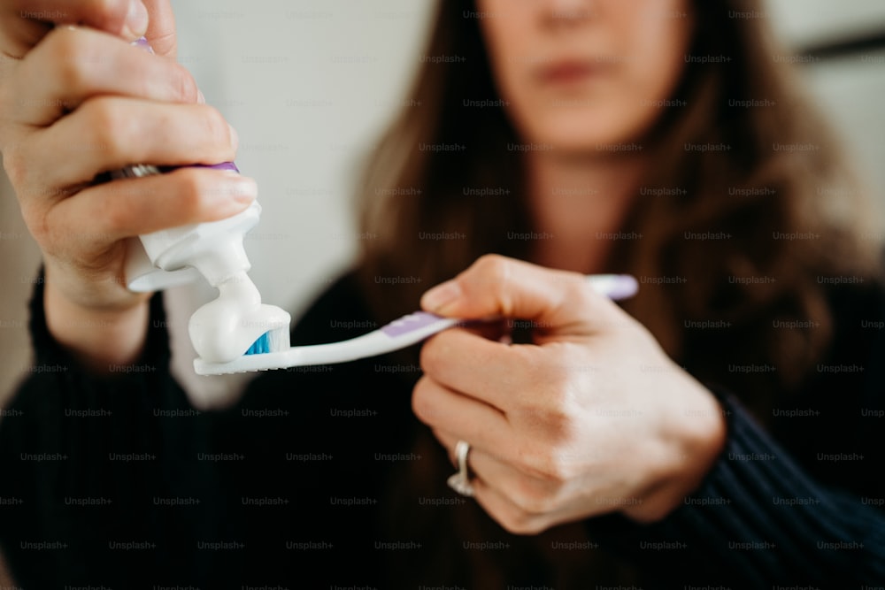 a close up of a person holding a toothbrush