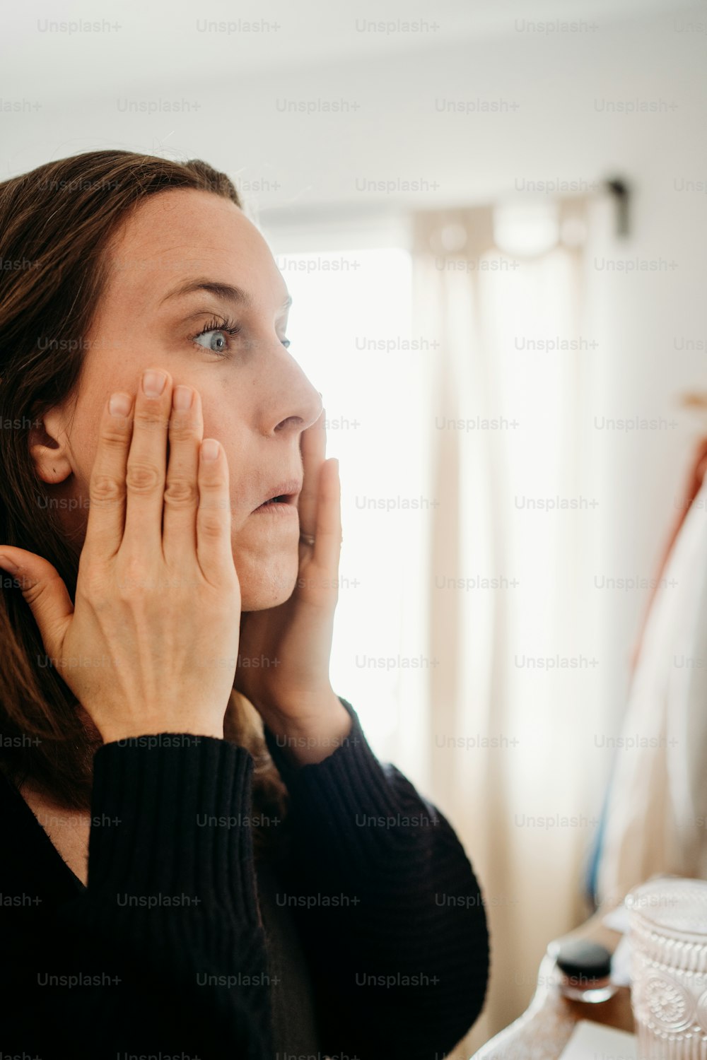 a woman holding her hand up to her face