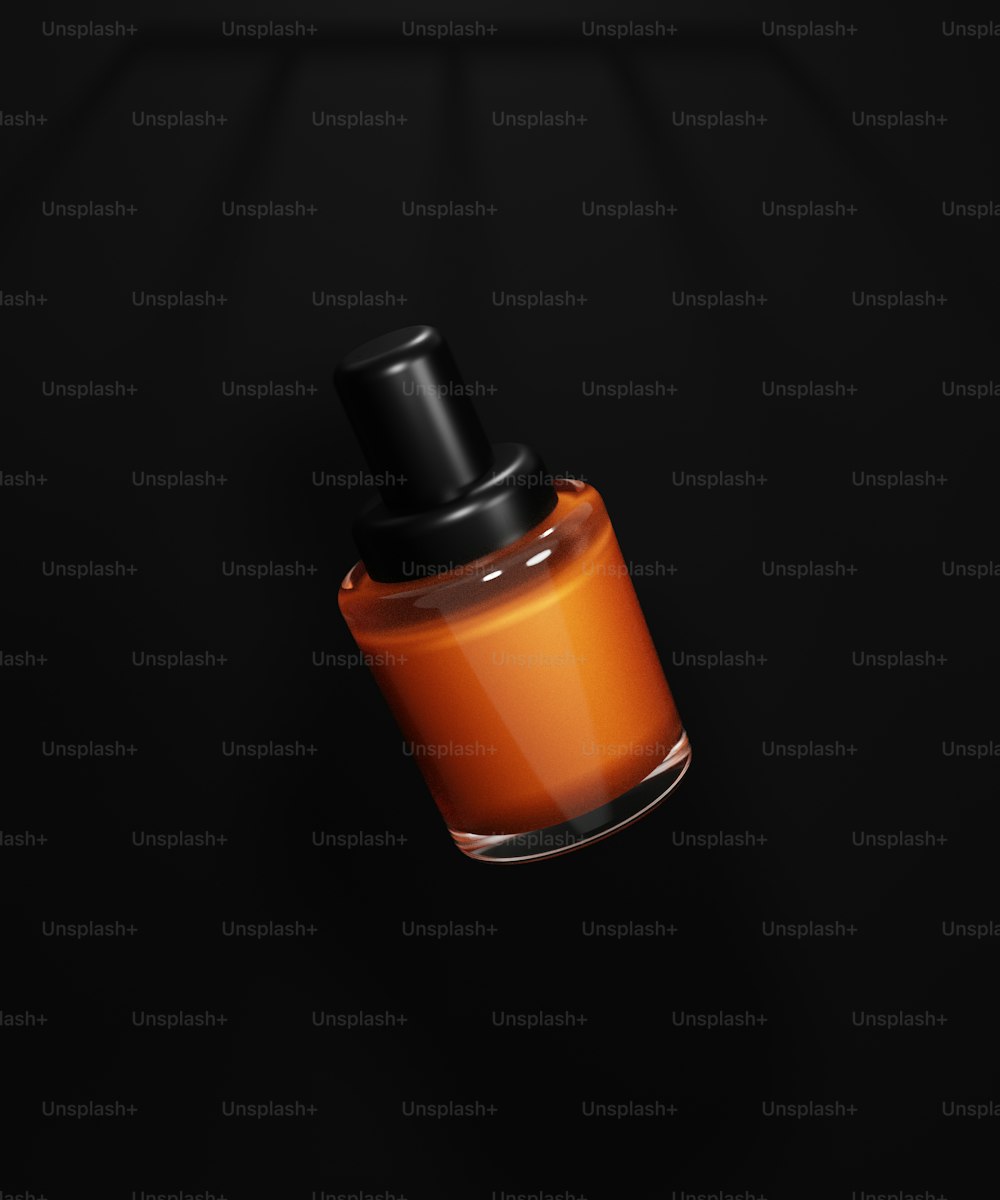 une bouteille orange avec un couvercle noir sur fond noir