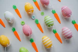 a table topped with lots of decorated eggs and carrots